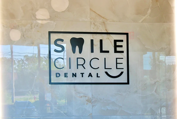 A Smile Circle Dental branded sign behind the front desk